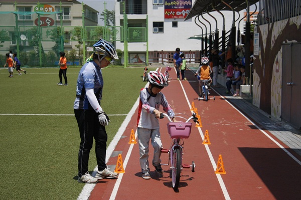 푸른바이크 강사가 한  학생의 자전거안전교육을 실시하고 있다.