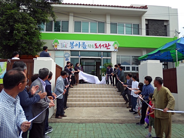 봉아름 작은 도서관 개관식에 참석한 내빈들이 개관텦을 끊고 있다.